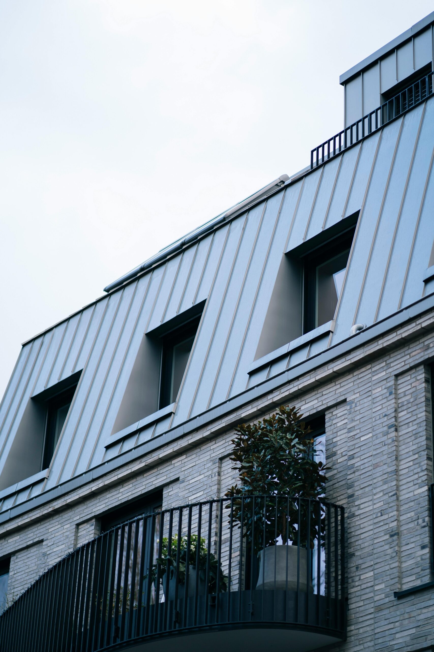 Contemporary building with steel design, featuring a stylish balcony and rooftop architecture.