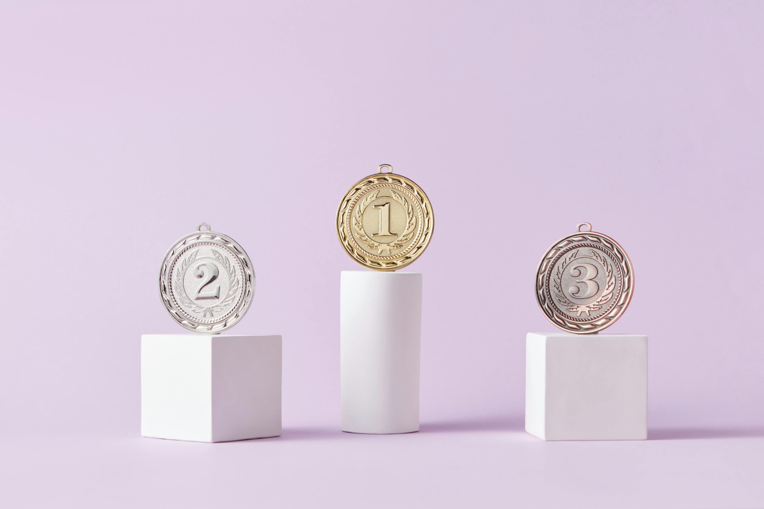 Medals on a podium against a soft pastel background, ideal for awards themes.